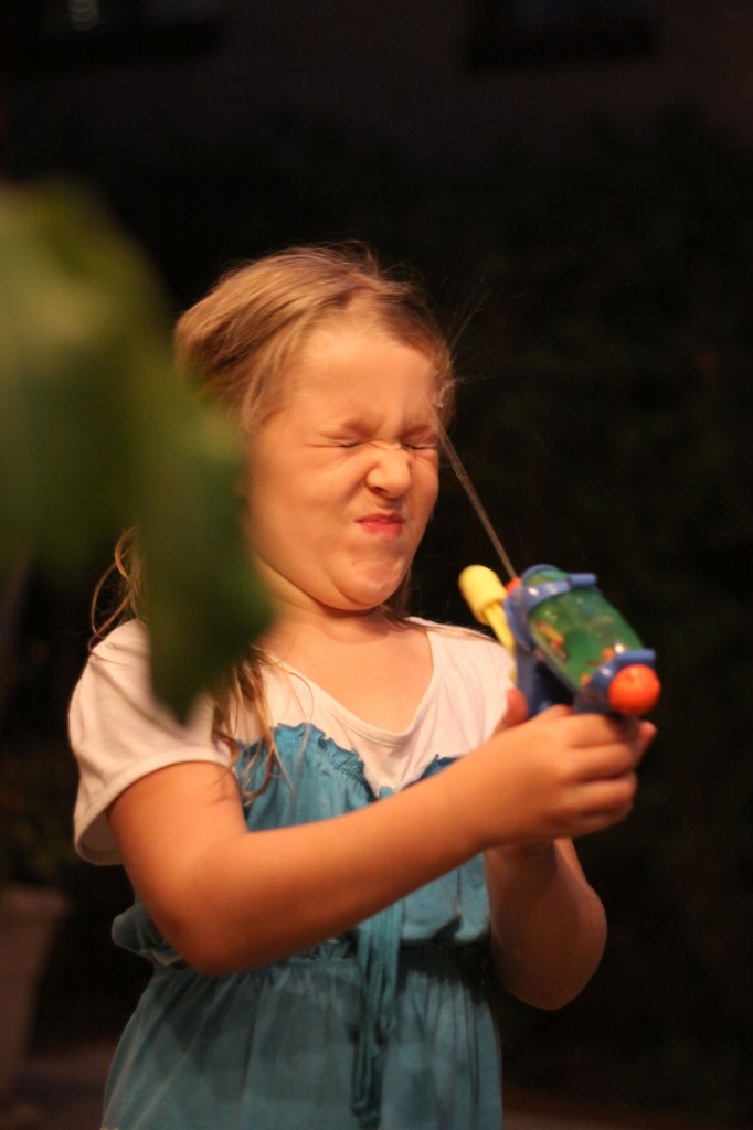 Girl squirting self in face with water-pistol